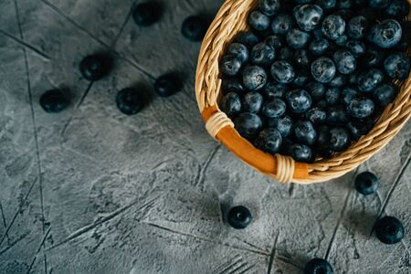 Fresh Blueberries in Wooden Basket on Table. Raw Organic Bilberry Close Up for Healthy Eating, Top Viewの写真素材