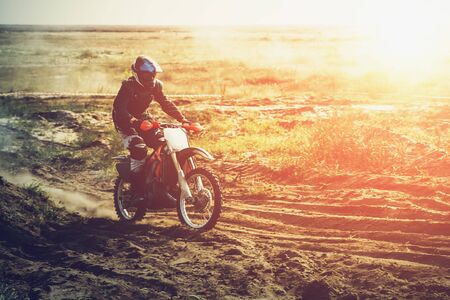 Motocross rider moves fast outdoor in sunlight with copy space, tonedの写真素材