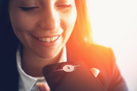 Young smiling business woman using smart phone voice message recognition or vocal digital AI...