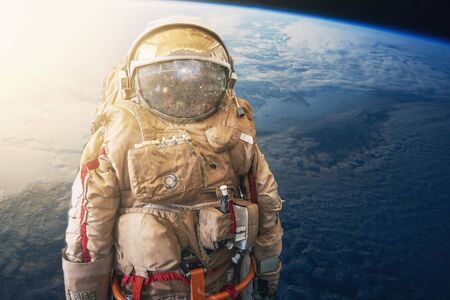 Cosmonaut or astronaut or spaceman in helmet at earth background view from outer space.