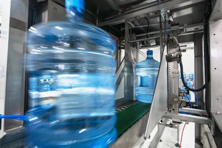 Automatic packaging of plastic bottles with clean drinking water in plastic or cellophane bag in...