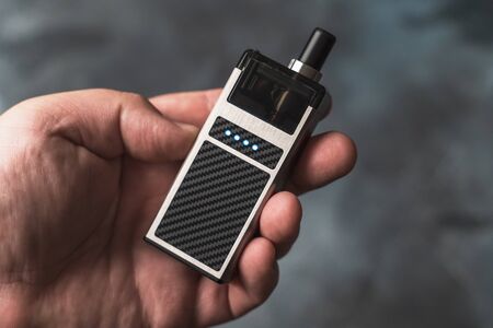 Vape pod in male hand or pod mod close up - newest generation of vaping products.の写真素材