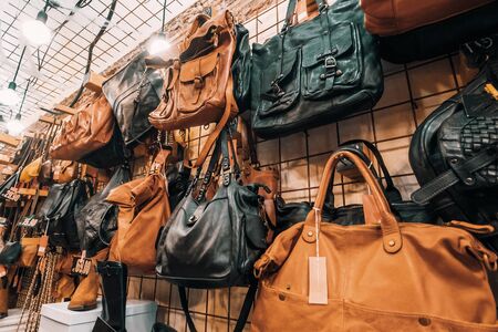 Female leather bags on wall in shop, accessories for women sale.の写真素材