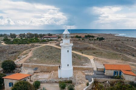Old lighthouse on Mediterranean Sea shore in Paphos, Cyprus, aerial view from drone. Famous place in Paphos coastline.の写真素材