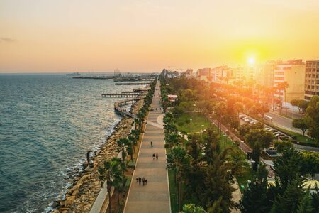 Sunset in Limassol, Cyprus. Mediterranean resort. Aerial panoramic view of Limassol city promenade with wooden piers in evening, drone photo.の写真素材