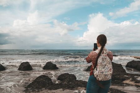 Young hipster girl or woman taking shot or recording video on smartphone or phone beautiful...