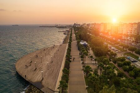Sunset in Limassol, Cyprus. Mediterranean resort. Aerial panoramic view of Limassol city promenade with wooden piers in evening, drone photo.の写真素材