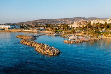 Aerial view from drone of small bay or harbor for boats and yachts in mediterranean coastline with beach and hotels on embankment at sunset, Cyprus travel concept.の写真素材