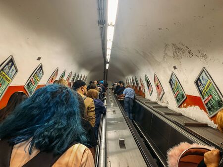 Rome, Italy - October 2019: crowd of people in metro escalator or elevator tunnel in Rome, Italy.