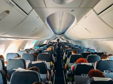 Airplane interior inside with passengers in flight.の写真素材