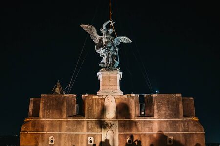Michael the Archangel bronze statue at night on top of Castle of Holy Angel in Rome, Italy.