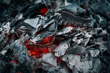 Burning coals, burned paper. Hot coal and flame with smoke from fire, close up.