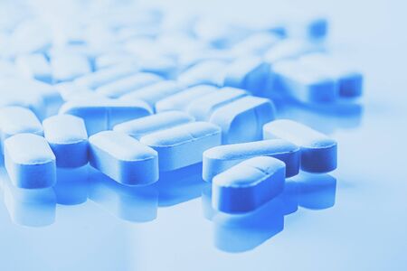 Medicine tablets or opioids medications, drug abuse and overdose concept in blue color.