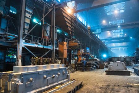 Interior of steel mill. Workers in workshop of metallurgical plant. Foundry and heavy industry building inside background.の写真素材