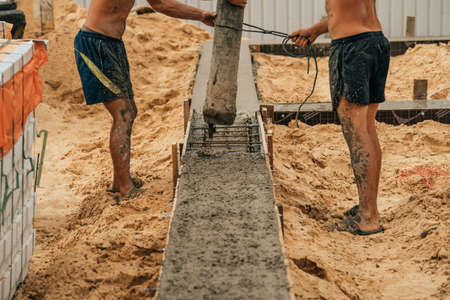 Pouring cement or concrete with automatic pump, construction site with reinforced grillage...