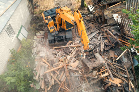 Process of demolition of old building dismantling. Excavator breaking house. Destruction of dilapidated housing for new development.の写真素材