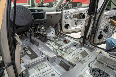 Car interior inside with seats and upholstery removed. Preparing for repair work or installing noise...