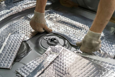 Process of installation of soundproofing material to inside of car. Auto sound insulation.の写真素材