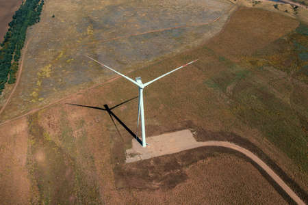 Wind turbines in green fields aerial view. Alternative electricity, sustainable resources, renewable...