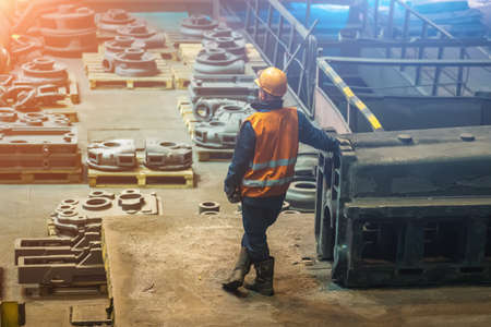 Metallurgical plant or foundry worker and large steel product in workshop.の写真素材