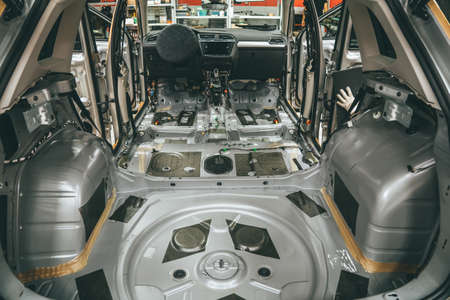 Car interior inside with seats and upholstery removed. Preparing for repair work or installing noise insulation soundproofing on modern SUV.の写真素材