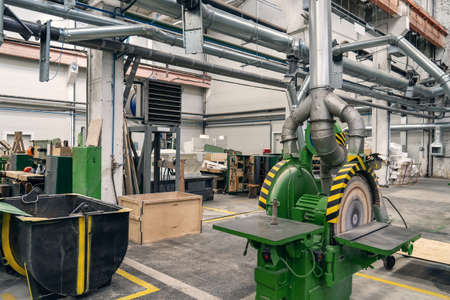 Woodwork factory with machines, lathes and steel pipes for processing.