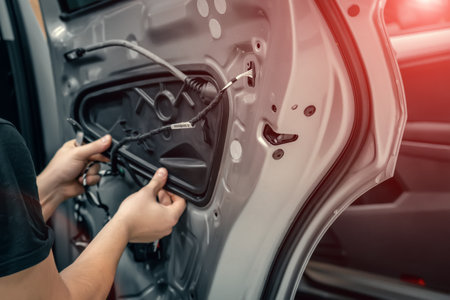 Auto service worker disassembles car door for repair close up.の写真素材