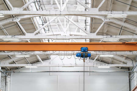 Overhead beam or bridge crane in industrial warehouse hangar building.の写真素材