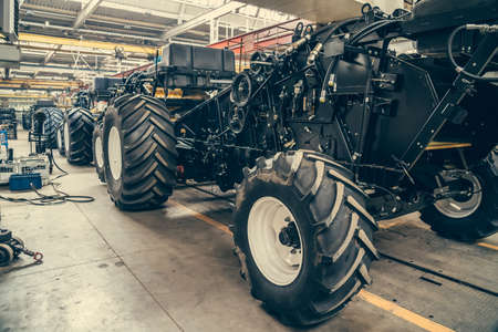 Conveyor line for production and assembly of large industrial machines, tractors or combines with big rubber tires in factory.の写真素材