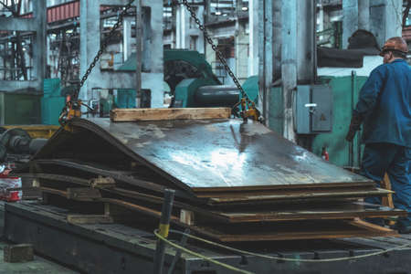 Metallurgical plant, unload steel or metal sheets with crane for steelmaking production.