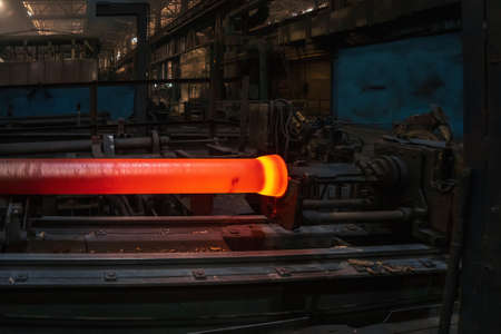 Freshly cast hot cast iron pipes at smelter. Manufacture of pipes for water, gas or oil.の写真素材