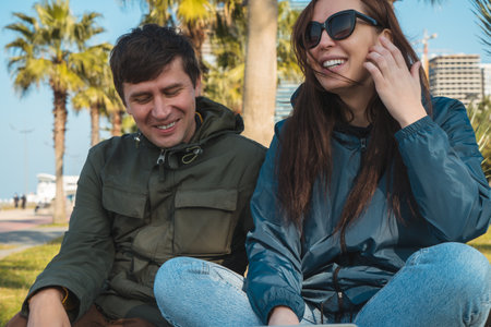 Happy couple or friends laughing in city park, man and woman spend time together.