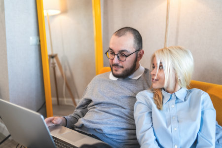 Young man and woman spend time together using laptop. Couple making online shopping purchases.の写真素材
