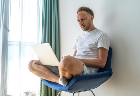 Middle aged Man working at laptop at home online shopping, making purchases in internet stores.の写真素材