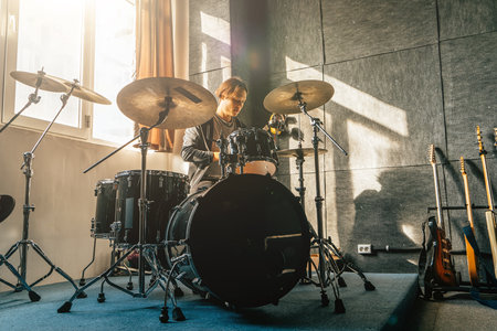 Portrait of drummer sitting at drum kit in sound recording studio at music band rehearsal.の写真素材