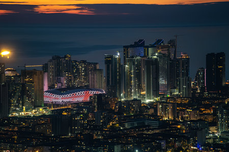 Batumi, Georgia, December 2023: Batumi Stadium with night illumination, view from mountain to Batumi city new modern buildings and big new modern Adjarabet Arena for soccer or football.のeditorial素材