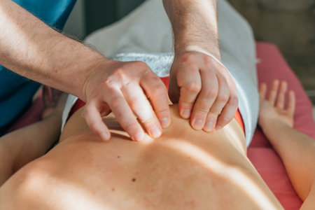 Massage therapist gives massage to patient, close-up. Wellness and revitalization massage and spa treatments.の写真素材