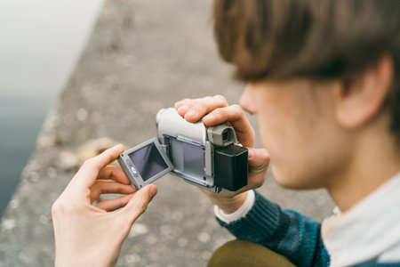 Hands holding and adjusting old-fashioned portable camera.の写真素材