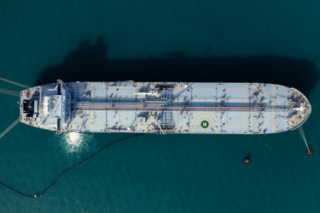 Tanker moored at oil terminal, intricate part of global petro resource trade, aerial view from drone. Key hub in industry logistics and distribution. Essential in the chain of energy supply andの写真素材