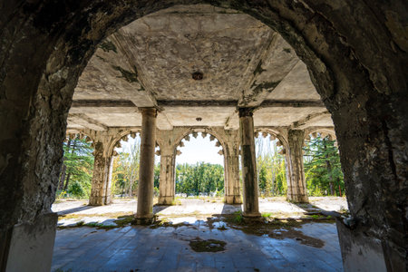 Perspective of ruined palace veranda framed by ancient arches and columns, blending light and shadows. Abandoned heritage site offers serene yet mysterious beauty.の写真素材