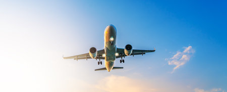 Airplane flying overhead against bright sky, symbolizing global travel, modern aviation, connection,...