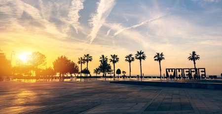 Sunset seafront view in Batumi Georgia with palm trees, fountains, urban architecture, romantic travel, summer vacation vibes.の写真素材