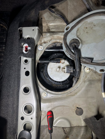 Exposed car fuel pump assembly with wiring and connectors during diagnostics or replacement, top view.の写真素材