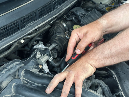 Car engine repair maintenance mechanic working with screwdriver tool on vehicle motor, automotive service.の写真素材
