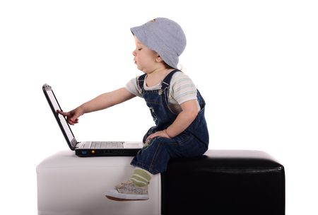 Little boy sitting with a laptop isolated on the whiteの写真素材