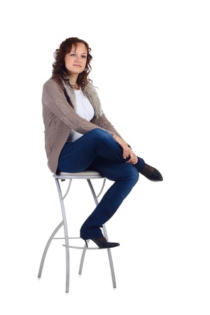 Girl sitting on the bar chair at white backgroundの写真素材