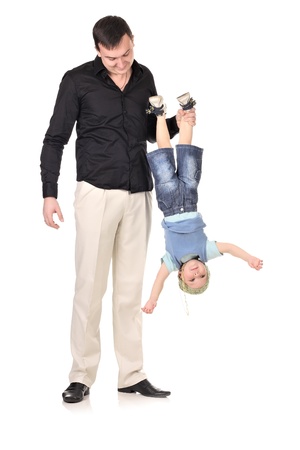 Man holds little boy upside down at white backgroundの写真素材