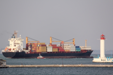 Big bulk-carrier with cardo near the  lighthouseの写真素材