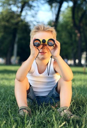Little boy looking through the binoculars in th parkの写真素材