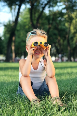 Little boy looking through the binoculars in th parkの写真素材